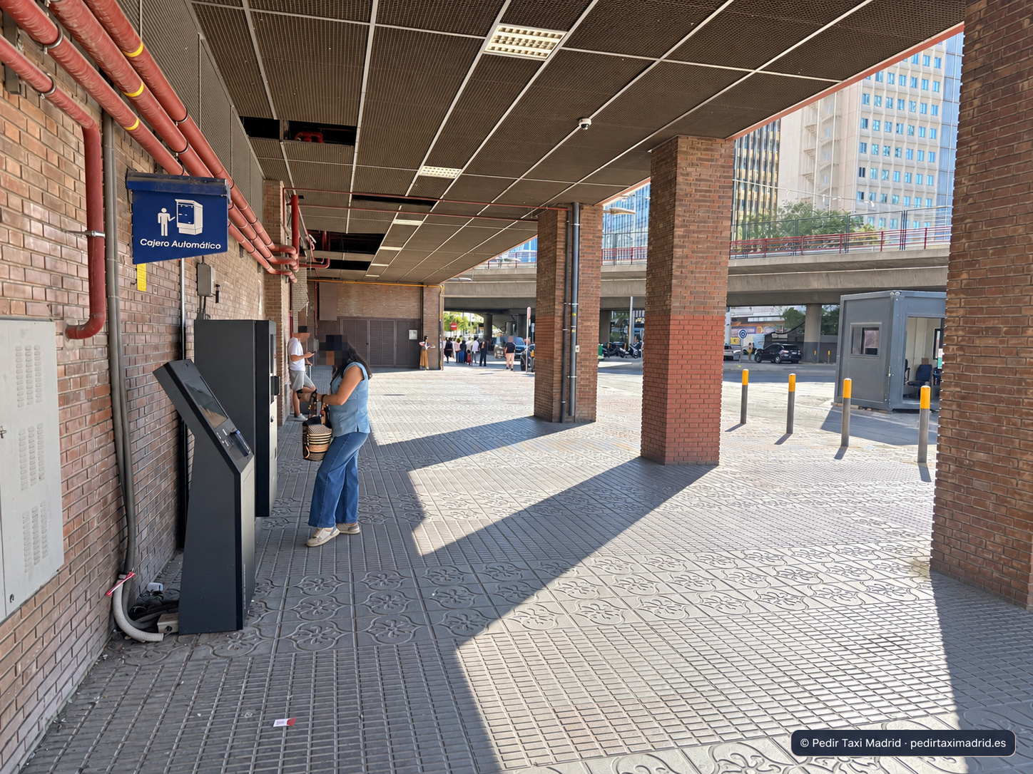Tramo cubierto de la acera con un cartel de cajero automático